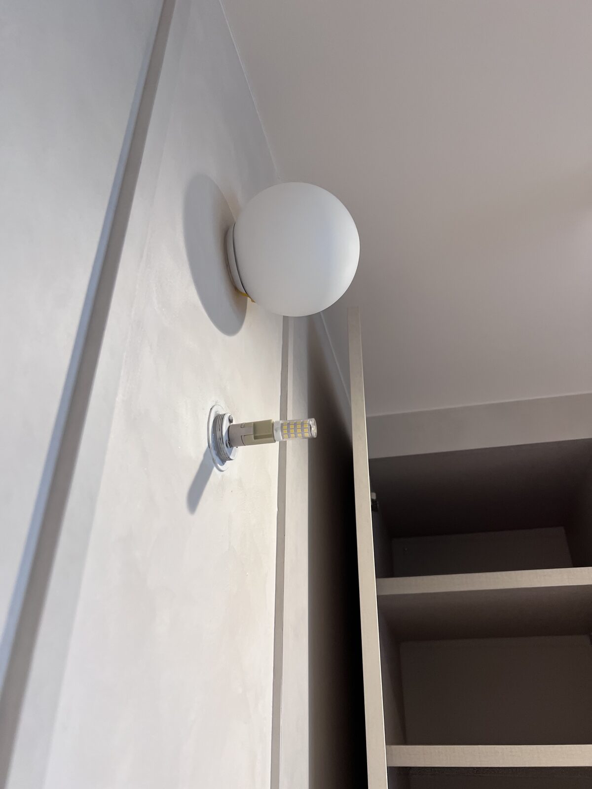 Boba wall light installed close to the limewash wall